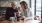 two women sitting at a table looking at a phone