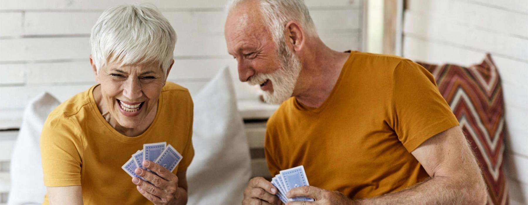 a man and woman sitting at a table playing cards at a pet friendly apartment in Dayton Ohio